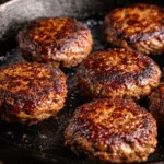 Crispy carnivore smash burger patties searing in a cast-iron skillet